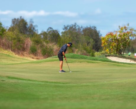 Golfer concentrating over a putt on a golf course